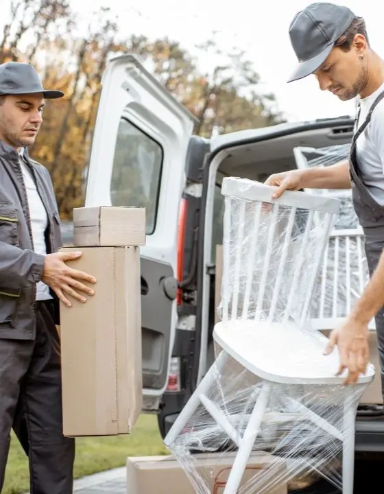 Removal team loading furniture and boxes into a van